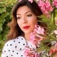 head of dark haired woman next to flowers